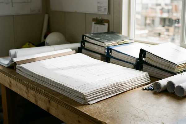 Permit drawing set and binders on a site office desk